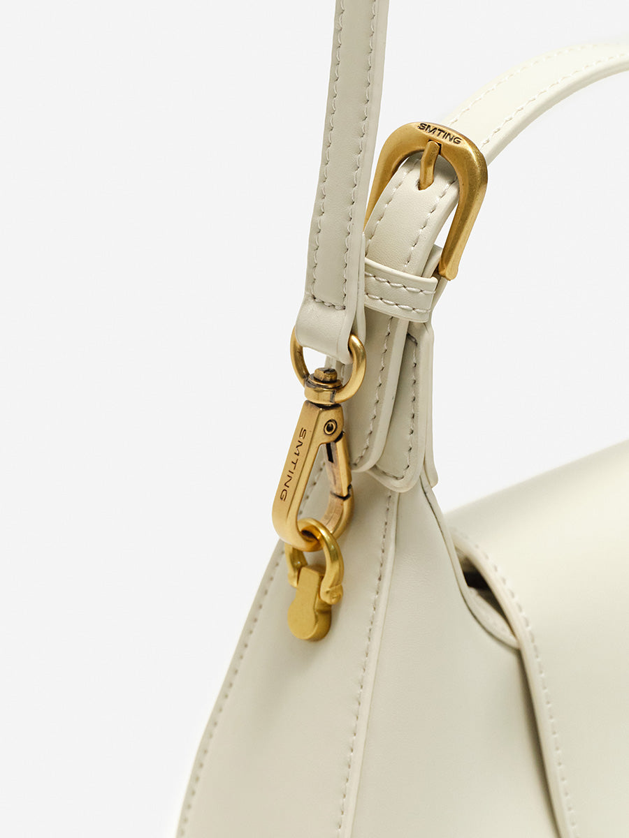 Crescent-shaped handbag with saddle design