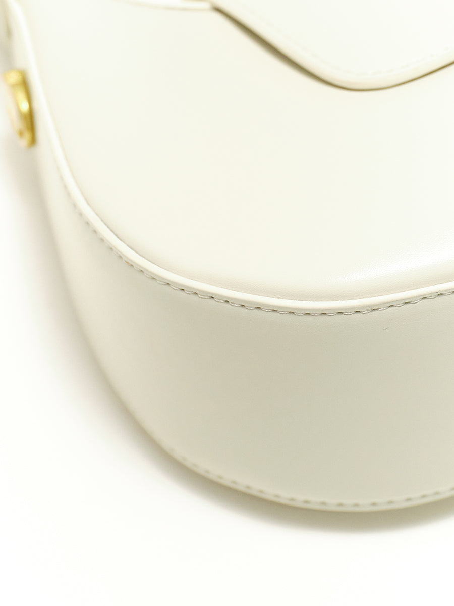 Crescent-shaped handbag with saddle design